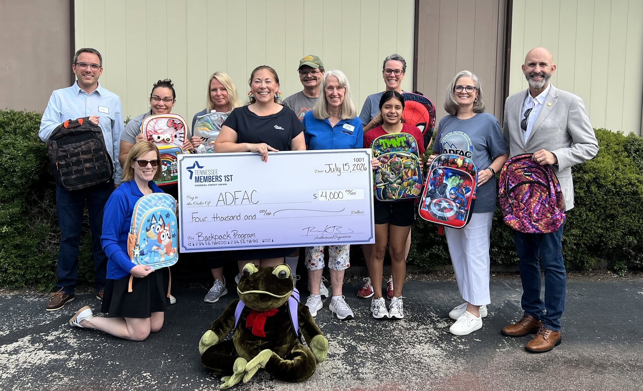 Richelle visits ADFAC to present a check for their school supplies program